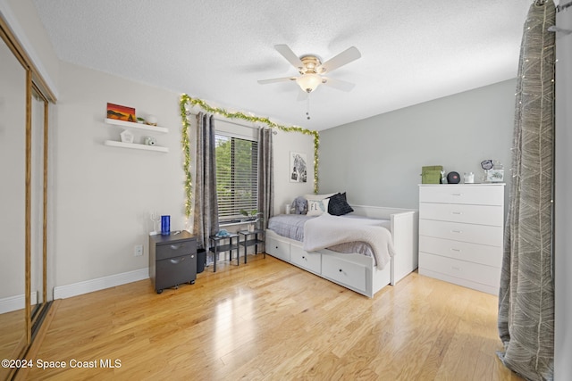 bedroom featuring ceiling fan, a closet, a textured ceiling, and hardwood / wood-style flooring