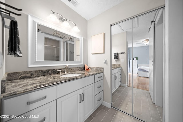 bathroom with vanity, a textured ceiling, and hardwood / wood-style flooring