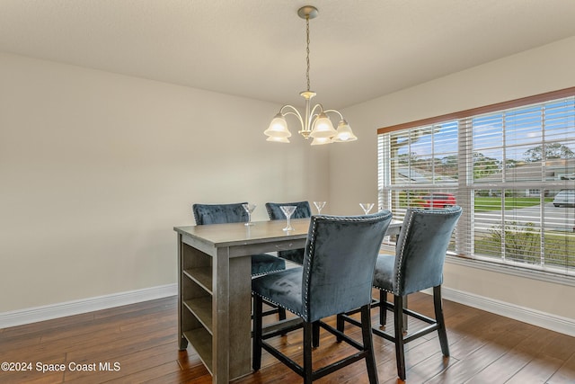 dining area featuring a wealth of natural light, dark wood-type flooring, and an inviting chandelier