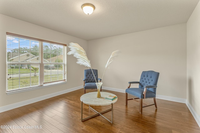 sitting room featuring wood-type flooring and a textured ceiling