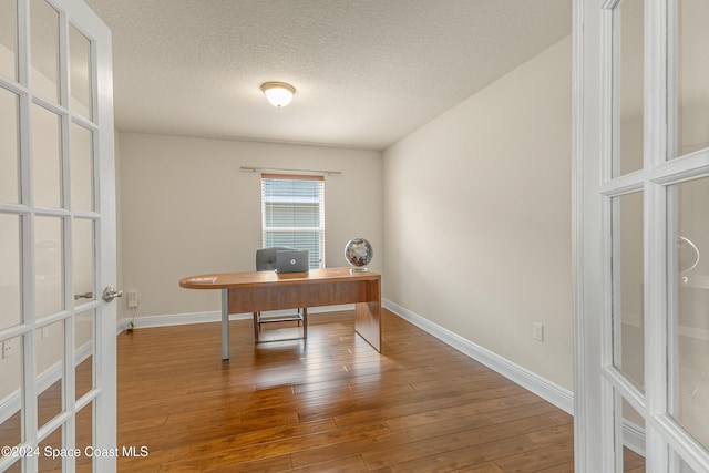 office featuring french doors, a textured ceiling, and hardwood / wood-style flooring