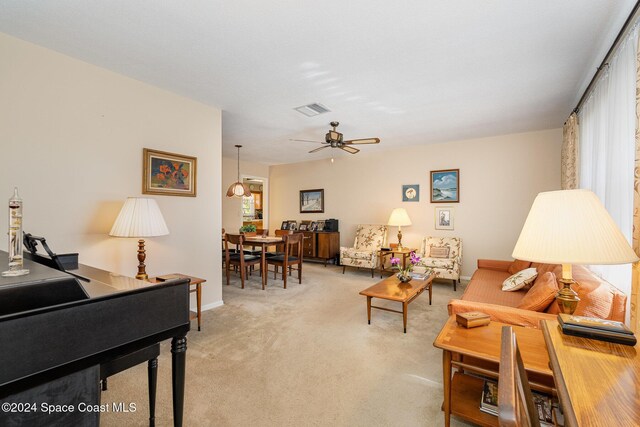 living room featuring a wealth of natural light, carpet floors, and ceiling fan