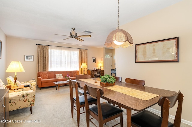 dining space featuring light colored carpet and ceiling fan