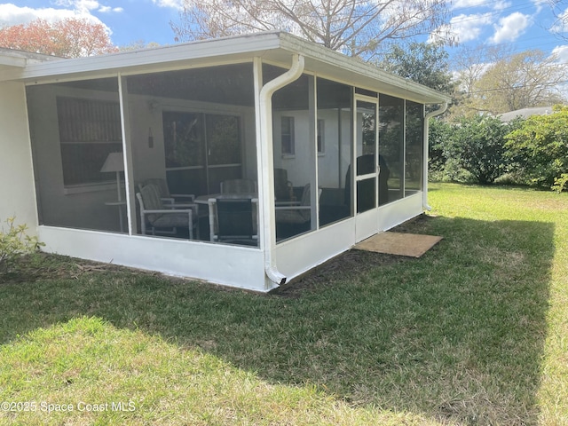 view of side of property featuring a sunroom and a lawn