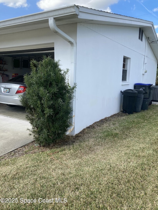 view of property exterior with a garage and a lawn