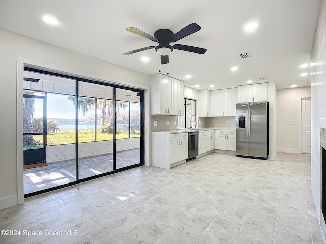 kitchen featuring sink, ceiling fan, tasteful backsplash, white cabinetry, and stainless steel appliances