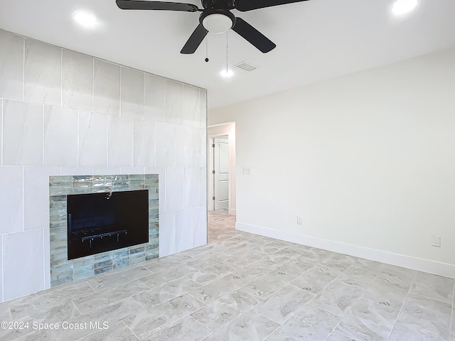 interior space with ceiling fan and a tiled fireplace