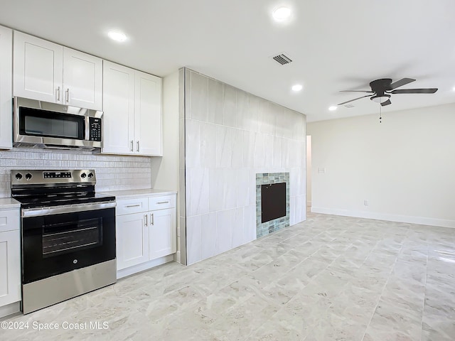 kitchen with appliances with stainless steel finishes, backsplash, white cabinetry, and ceiling fan