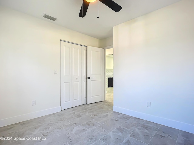 unfurnished bedroom featuring ceiling fan and a closet