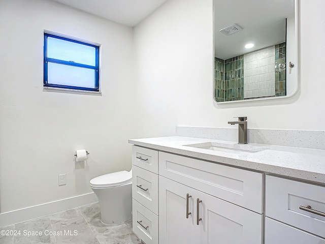 bathroom featuring vanity, toilet, and walk in shower