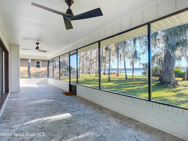 unfurnished sunroom with a water view and ceiling fan