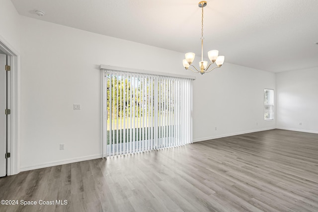 unfurnished room featuring hardwood / wood-style floors and a notable chandelier