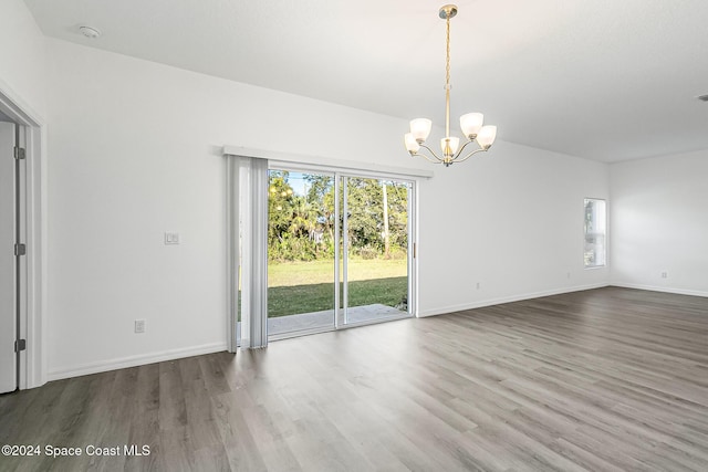 interior space featuring plenty of natural light, an inviting chandelier, and hardwood / wood-style flooring