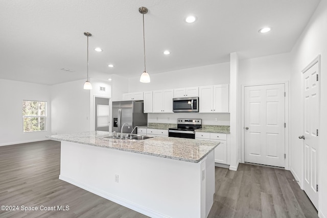 kitchen featuring white cabinets, appliances with stainless steel finishes, a kitchen island with sink, and sink