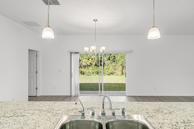 kitchen with a chandelier, sink, hardwood / wood-style floors, and decorative light fixtures