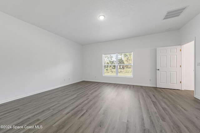 spare room featuring hardwood / wood-style flooring and a textured ceiling