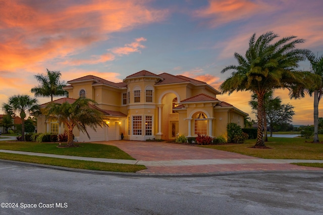 mediterranean / spanish-style house with a yard, french doors, and a garage