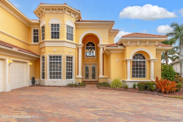 view of front of home with a garage and french doors