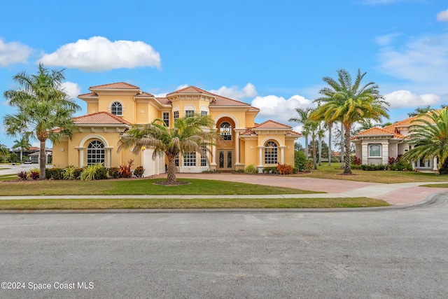 mediterranean / spanish-style home with french doors and a front lawn