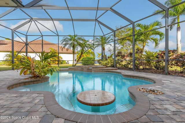 view of pool with a patio area and a lanai