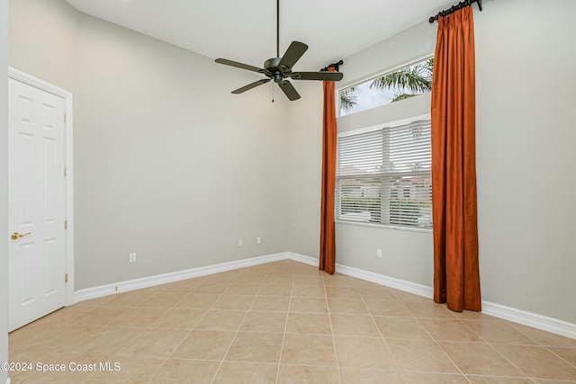 tiled empty room featuring ceiling fan