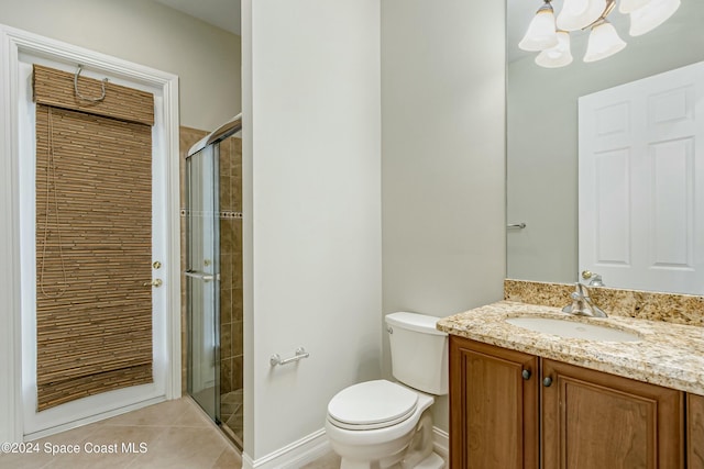 bathroom with vanity, tile patterned floors, toilet, a shower with shower door, and a chandelier