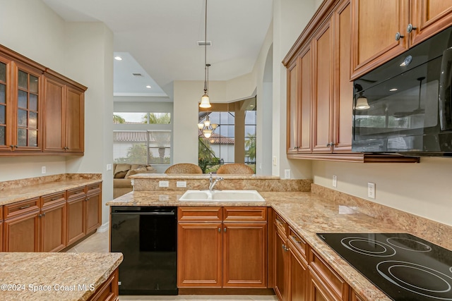 kitchen featuring pendant lighting, black appliances, sink, light stone counters, and a chandelier