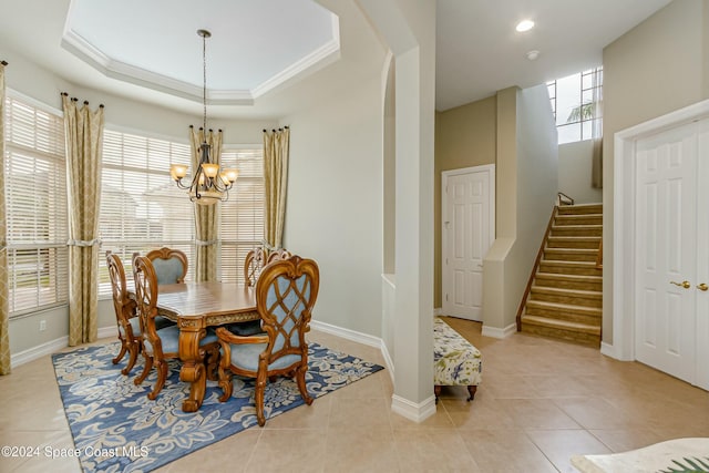 dining room featuring a raised ceiling, light tile patterned flooring, and a notable chandelier