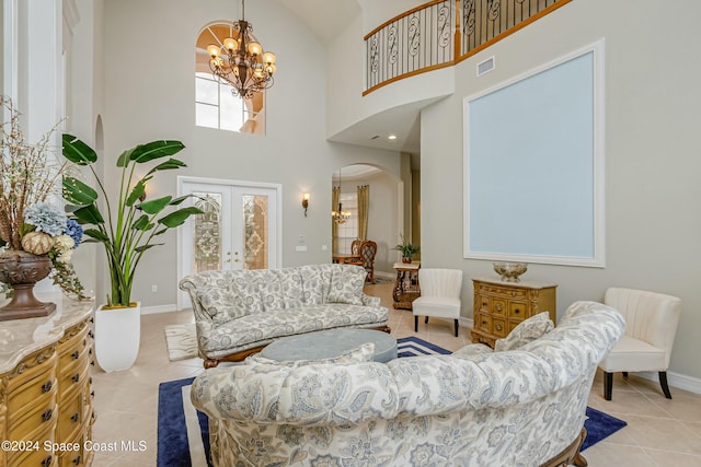 living room with a chandelier, french doors, a towering ceiling, and light tile patterned floors