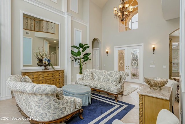 sitting room with a high ceiling, an inviting chandelier, light tile patterned floors, and french doors