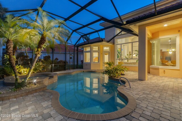 view of pool with a lanai, an in ground hot tub, and a patio