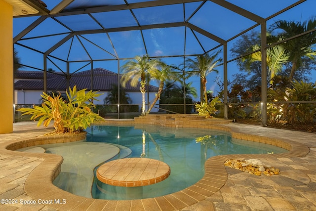 view of swimming pool with a patio and glass enclosure