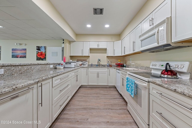 kitchen with white cabinetry, sink, and white appliances