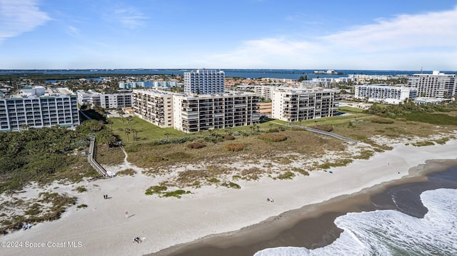 birds eye view of property with a water view and a beach view