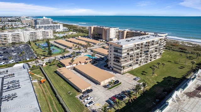 drone / aerial view featuring a beach view and a water view