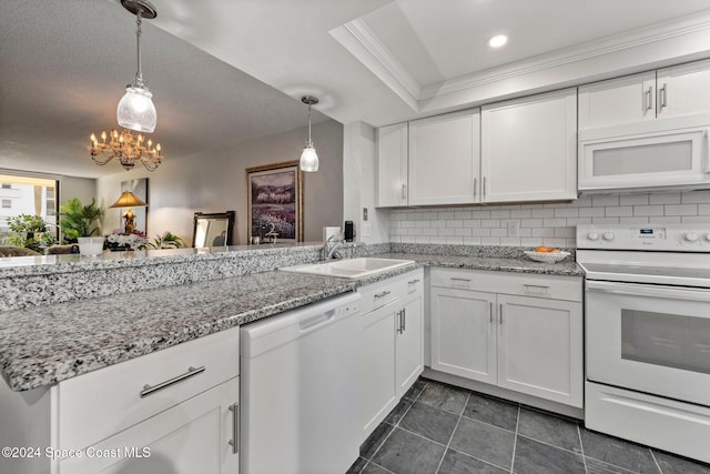 kitchen with white appliances, a sink, white cabinets, pendant lighting, and tasteful backsplash