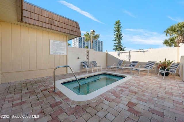 view of swimming pool featuring a patio area, a fenced backyard, and a hot tub