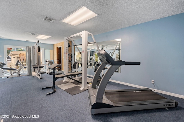 gym featuring visible vents, baseboards, and a textured ceiling