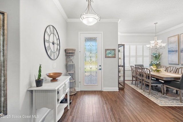 foyer with ornamental molding, dark wood-type flooring, and a notable chandelier