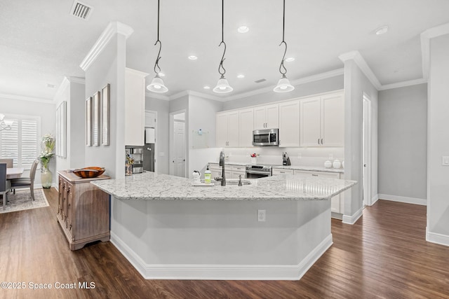 kitchen featuring sink, light stone counters, pendant lighting, white cabinets, and appliances with stainless steel finishes