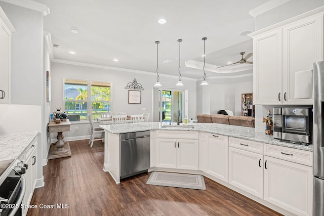 kitchen featuring kitchen peninsula, appliances with stainless steel finishes, white cabinetry, and pendant lighting