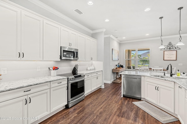 kitchen featuring appliances with stainless steel finishes, white cabinetry, hanging light fixtures, and sink