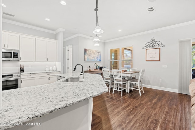 kitchen with white cabinetry, stove, decorative light fixtures, and sink