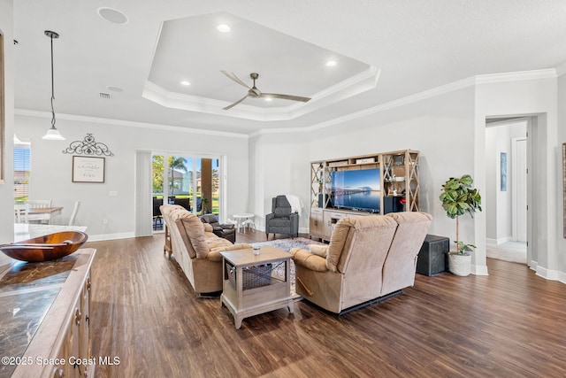 living room with ceiling fan, dark hardwood / wood-style floors, ornamental molding, and a tray ceiling