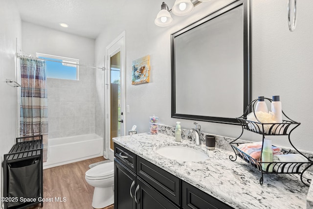 full bathroom with hardwood / wood-style floors, vanity, shower / bath combination with curtain, and toilet