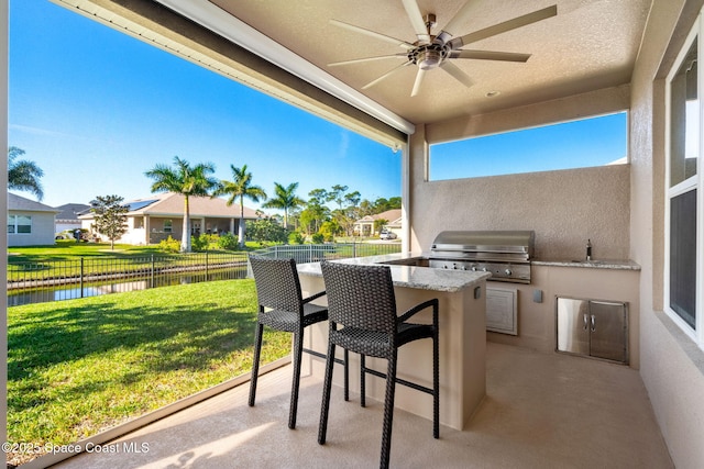 view of patio / terrace with ceiling fan, a water view, and grilling area