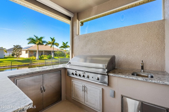 view of patio / terrace with sink, a water view, area for grilling, and a grill