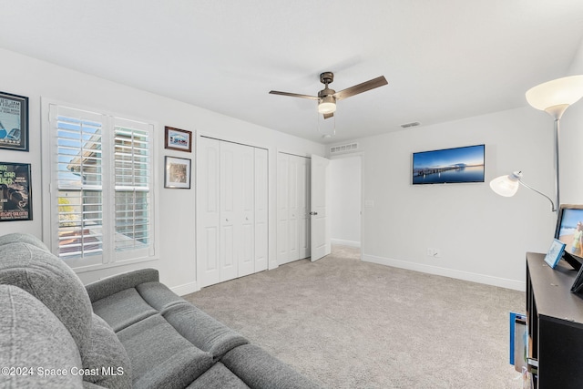 carpeted living room featuring a wealth of natural light and ceiling fan