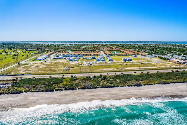 birds eye view of property with a water view and a beach view