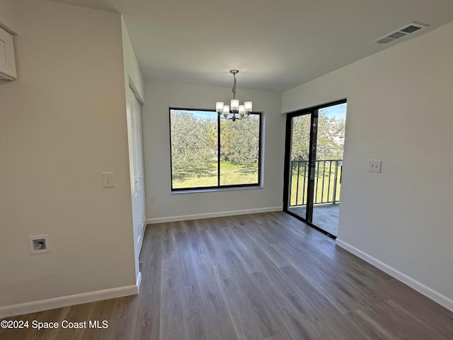 unfurnished dining area featuring hardwood / wood-style flooring and a notable chandelier